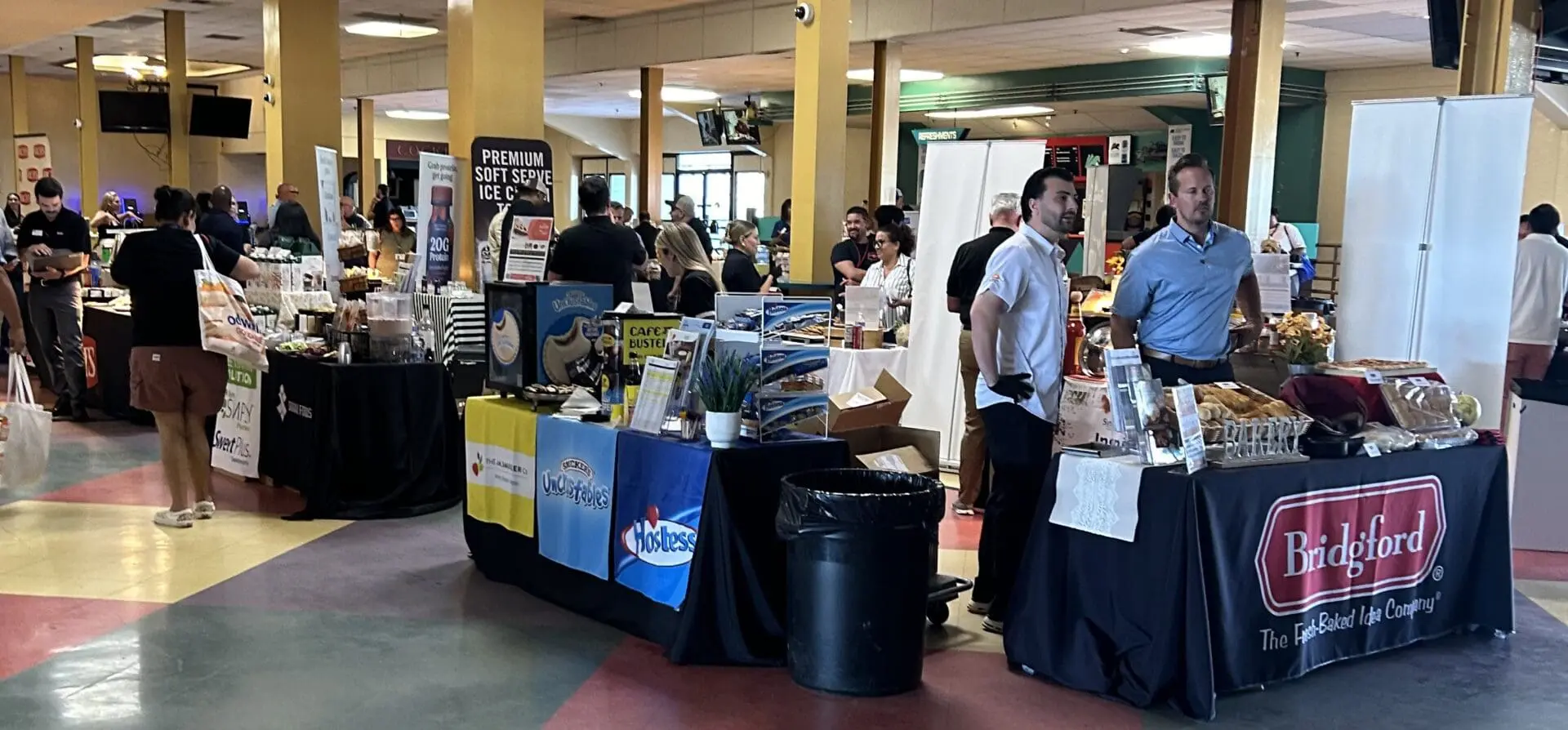 Indoor market with various vendor booths.